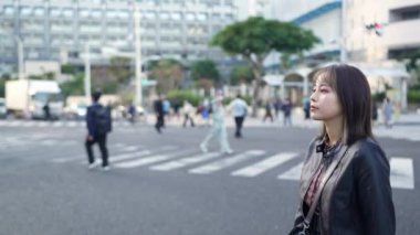 Okinawa 'nın Naha şehrinin Kokusai Caddesi yakınlarındaki bir alışveriş sokağında 20' li yaşlarda, kışın gezen bir kadının yavaş çekim videosu.
