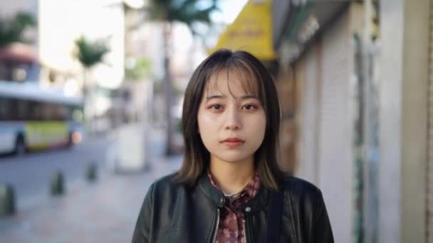 冲绳Naha市Kokusai街一名20多岁穿着冬衣的冲绳妇女脸部慢镜头 — 图库视频影像