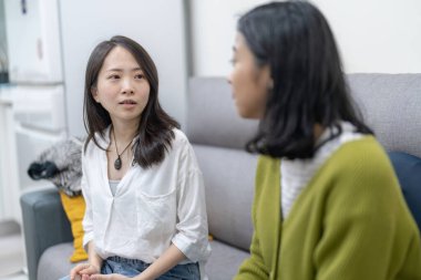 Kanepede oturup 30 'lu yaşlardaki Tayvanlı kadınlar ve 20' li yaşlardaki Asyalı kadınlar arasındaki tartışma sahnesi.