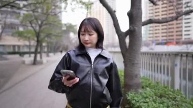 20 'li yaşlarda Japon bir kadın kışın Tokyo' da, Shinagawa 'da Gotanda İstasyonu' nun etrafında yürüyor.