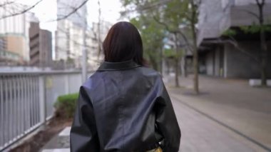 20 'li yaşlarda Japon bir kadın kışın Tokyo' da, Shinagawa 'da Gotanda İstasyonu' nun etrafında yürüyor.