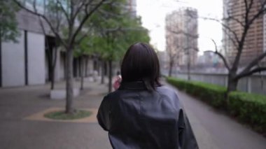 20 'li yaşlarda Japon bir kadın kışın Tokyo' da, Shinagawa 'da Gotanda İstasyonu' nun etrafında yürüyor.