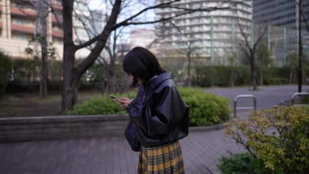 Een Japanse Vrouw Die Stopt Haar Smartphone Gebruikt Een Weg — Stockvideo