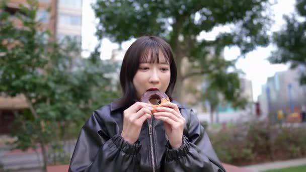 Une Femme Japonaise Dans Vingtaine Qui Mange Des Beignets Assis — Video