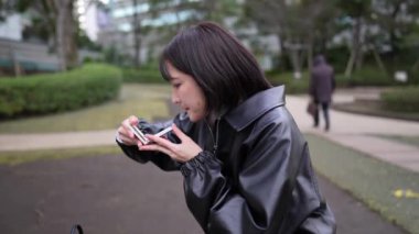 Japon bir kadının kışın Gotanda, Shinagawa-ku, Tokyo yakınlarındaki bir parkta oturup makyaj yaptığı yavaş çekim videosu. 