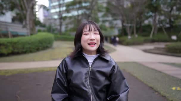 東京都品川区五田駅周辺の公園に座っている20代の若い日本人女性のスローモーションビデオ — ストック動画