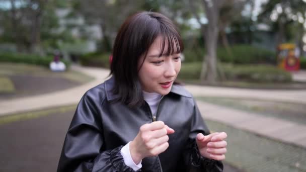 Vídeo Cámara Lenta Una Joven Japonesa Unos Años Sentada Parque — Vídeos de Stock