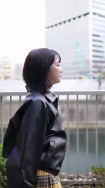 20 'li yaşlarda genç bir Japon kadının kışın Tokyo, Shinagawa' daki Gotanda İstasyonu 'nda yürüdüğü dikey bir video.