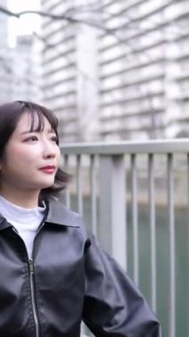 20 'li yaşlarda genç bir Japon kadının kışın Tokyo, Shinagawa' daki Gotanda İstasyonu 'nda yürüdüğü dikey bir video.