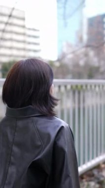 20 'li yaşlarda genç bir Japon kadının kışın Tokyo, Shinagawa' daki Gotanda İstasyonu 'nda yürüdüğü dikey bir video.
