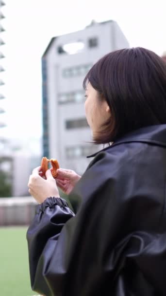 Vídeo Vertical Uma Jovem Japonesa Anos Sentada Comendo Churros Parque — Vídeo de Stock