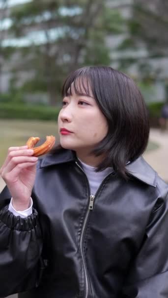 Vídeo Vertical Una Joven Japonesa Unos Años Sentada Comiendo Churros — Vídeos de Stock