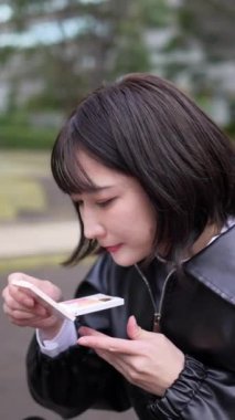 20 'li yaşlarda genç bir Japon kadının oturduğu dikey video.