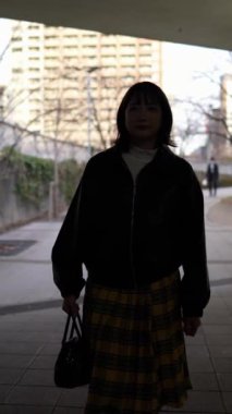 Japon bir kadının kışın Gotanda İstasyonu, Shinagawa-ku, Tokyo 'da yürüdüğünü gösteren dikey yavaş çekim videosu.