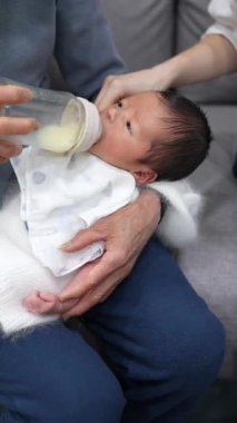 8 günlük Tayvanlı bir bebeğin dikey videosu mavi bir naylona sarılmış ve yeni doğan bir bebeğin fotoğrafını çekiyor.