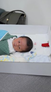Kanepede uyuyan 8 günlük Tayvanlı bir bebeğin dikey videosu.