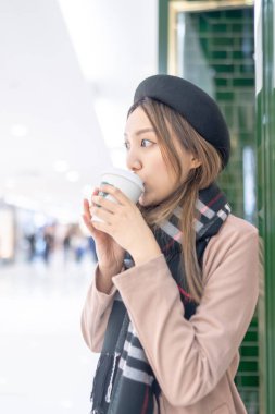 Hong Kong, Kowloon 'daki bir alışveriş merkezinde 20' li yaşlarında kahve içen genç bir Hong Kong 'lu kadın. 