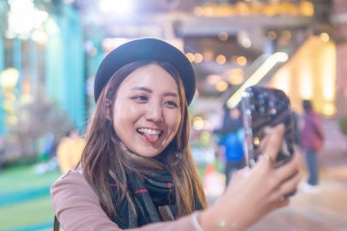 Hong Kong, Kowloon 'daki bir alışveriş merkezinin önünde 20' li yaşlarda genç bir Hong Kong 'lu kadın selfie çekiyor.