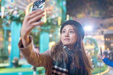 Hong Kong, Kowloon 'daki bir alışveriş merkezinin önünde 20' li yaşlarda genç bir Hong Kong 'lu kadın selfie çekiyor.