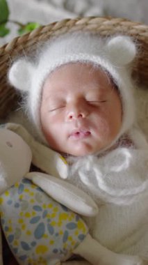 8 günlük Tayvanlı bir bebeğin mavi bir naylona sarılı yeni doğmuş bir bebeğin dikey yavaş çekim videosu.
