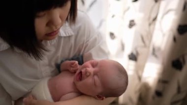 20 'li yaşlarda Tayvanlı bir anne, bir aylık bebeğine kapalı bir perdenin önünde işkence ediyor..