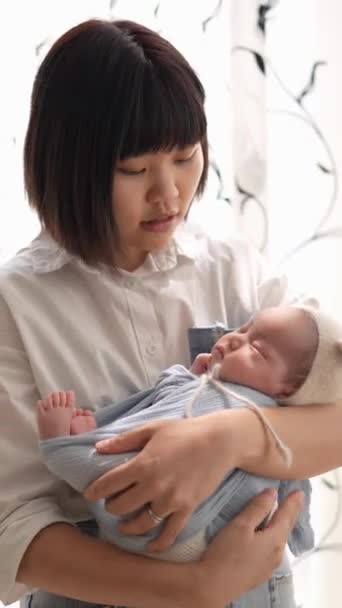 一位20多岁的台湾母亲在室内窗帘前扭伤了一位1个月大的女婴 — 图库视频影像