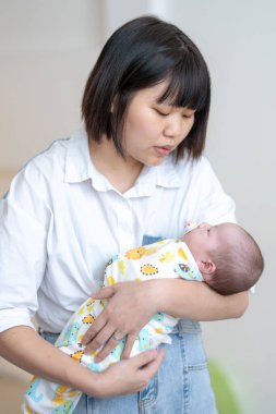 Yilan, Tayvan 'da yaşayan 20' li yaşlarda bir anne bir aylık Tayvanlı bir bebeğe bakıyor.