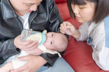 Yilan, Tayvan 'da yaşayan 20' li yaşlarında bir anne ve baba bir aylık Tayvanlı bebeğe bakıyor.