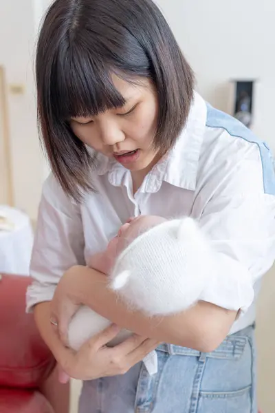 一位住在台湾宜兰的20多岁的母亲正在照看一个一个月大的台湾婴儿 图库图片