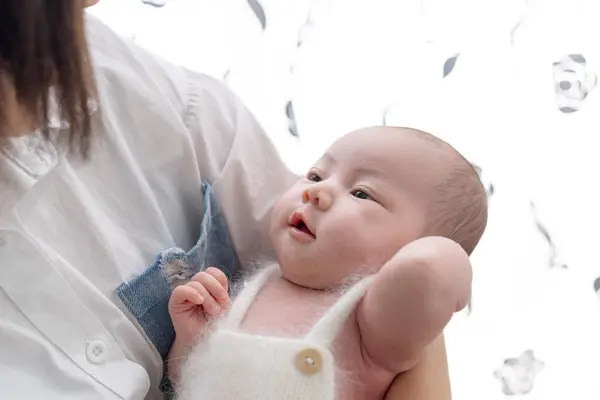 一位住在台湾宜兰的20多岁的母亲正在照看一个一个月大的台湾婴儿 免版税图库图片