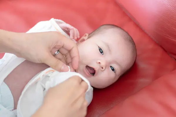 一位住在台湾宜兰的20多岁的母亲正在照看一个一个月大的台湾婴儿 免版税图库照片