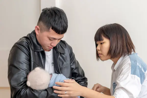 一位20多岁的母亲和父亲住在台湾宜兰 照顾着一个多月大的台湾婴儿 图库照片