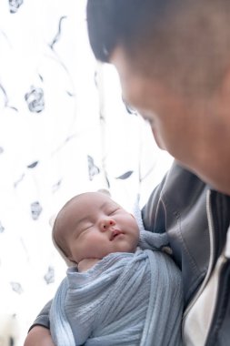 Yilan, Tayvan 'da yaşayan 20' li yaşlarda bir baba bir aylık Tayvanlı bir bebeğe bakıyor..