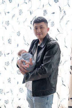 Yilan, Tayvan 'da yaşayan 20' li yaşlarda bir baba bir aylık Tayvanlı bir bebeğe bakıyor..