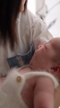 20 'li yaşlarda Tayvanlı bir annenin 1 aylık bir kızı iç mekan perdesinin önünde becerdiği dikey yavaş çekim videosu.