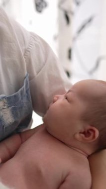 20 'li yaşlarda Tayvanlı bir annenin 1 aylık bir kızı iç mekan perdesinin önünde becerdiği dikey yavaş çekim videosu.