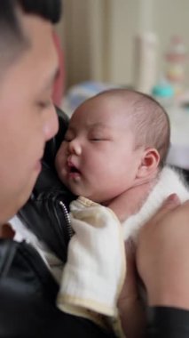 20 'li yaşlarda Tayvanlı bir anne ve annenin kırmızı bir koltukta 1 aylık geğiren bir bebek doğururken çekilmiş dikey videosu.