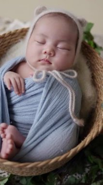 32 günlük Tayvanlı bir bebek mavi bir naylona sarılır ve dikey ağır çekimde yeni doğan bir bebeğin fotoğrafını çeker.. 