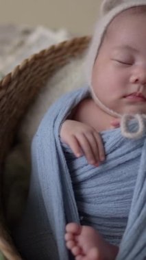 32 günlük Tayvanlı bir bebek mavi bir naylona sarılır ve dikey ağır çekimde yeni doğan bir bebeğin fotoğrafını çeker.. 