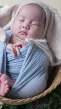 32 günlük Tayvanlı bir bebek mavi bir naylona sarılır ve dikey ağır çekimde yeni doğan bir bebeğin fotoğrafını çeker.. 