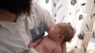 20 'li yaşlarda Tayvanlı bir annenin 1 aylık bir kızın bebeğini odanın perdesinin önünde şarkı söylerken ki yavaş çekim videosu.