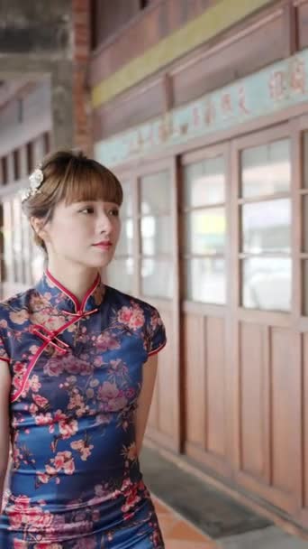 台湾台北市万化区 一名20多岁身穿蓝色传统服装旗袍的台湾妇女走过宝皮里奥历史街区的垂直录像 — 图库视频影像