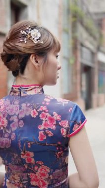 Tarihi Bopiliao Tarihi Blok, Wanhua İlçesi, Taipei Şehri, Taiwa Bölgesi 'ndeki yaya geçidinde yürüyen 20' li yaşlarda, geleneksel bir Çin elbisesi giyen Tayvanlı bir kadının dikey yavaş çekim videosu.