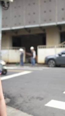 Tayvan, Tayvan 'da Wanhua bölgesinde geleneksel Çin elbisesi giyen 20' li yaşlarda bir Tayvanlı kadının yaya geçidinde akıllı bir telefonla yürüdüğü dikey yavaş çekim videosu.