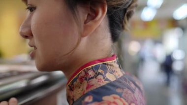 Geleneksel mavi Cheongsam 'lı genç Tayvanlı bir kadın Tayvan' ın Taipei şehrindeki Wanhua bölgesinde bir dükkandan balonlu çay sipariş ediyor. Yavaş çekim.