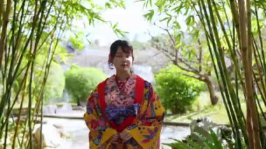 Geleneksel Ryusou giyimli yirmili yaşlarda genç bir kadın Okinawa 'daki güzel bir Çin bahçesinde zarifçe geziniyor. Çevrenin kültürel karışımını ve dingin güzelliğini vurguluyor..