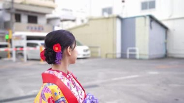 Yavaş çekim, Okinawan Ryuso 'da genç bir kadın olarak kültürel mirasın özünü yakalar. Modern şehir manzarasında yol alır. Her adımında gelenek ve gelişimin uyumlu bir karışımıdır..
