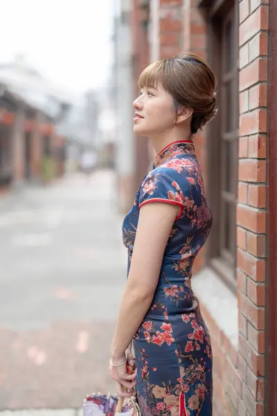 stock image Young Taiwanese woman in her 20s wearing a blue cheongsam, standing and observing the surroundings in a cultural district of Wanhua, Taipei, Taiwan