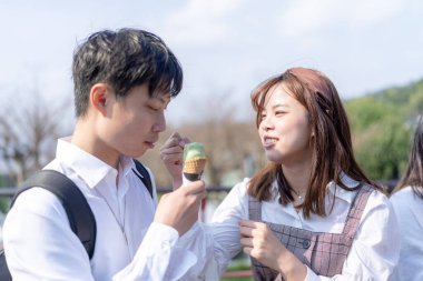 20 'li yaşlarda genç Tayvanlı bir çift, üniversite öğrencileri, Maokong, Wenshan Bölgesi, Taipei, Tayvan' da bir kafede satılan yumuşak servis dondurmalarını mutlulukla paylaşıyorlar.