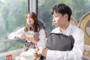 20 'li yaşlarının başında genç Tayvanlı bir çift, üniversite öğrencileri, Maokong, Wenshan Bölgesi, Tayvan, Tayvan' da gondolda birlikte vakit geçiriyorlar.